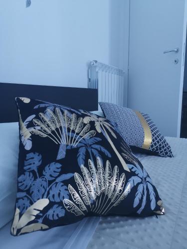 a blue and white pillow sitting on a bed at Appartamento Porta Castello - Affitti Brevi Italia in LʼAquila