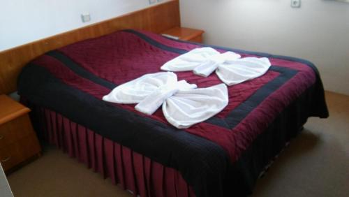 a bed with two white bows on top of it at Hotel Baykal in Bogazkale