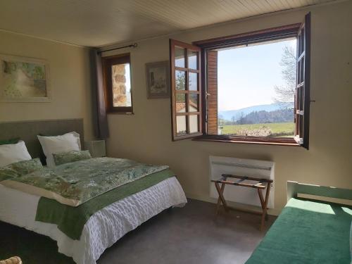 - une chambre avec un lit et une fenêtre dans l'établissement Ferme Auberge Linossier, à Burdignes