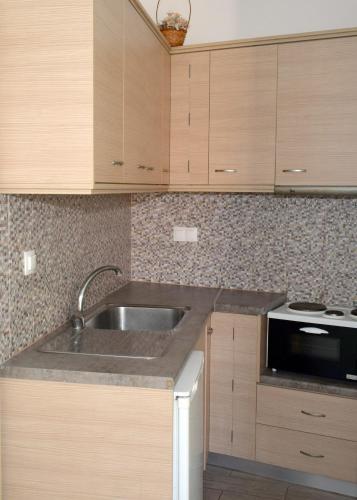 a kitchen with a sink and a microwave at En Plo Studios & Apartments in Plakias
