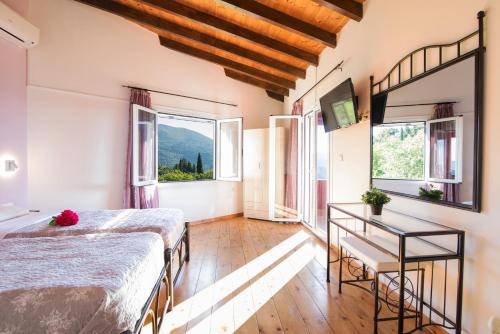 a bedroom with two beds and a table and windows at Villa PANGALIS Romantica in Kato Pavliana