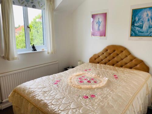 a bed with a bedspread with roses on it at Camelot Retreat - Tor View in Glastonbury