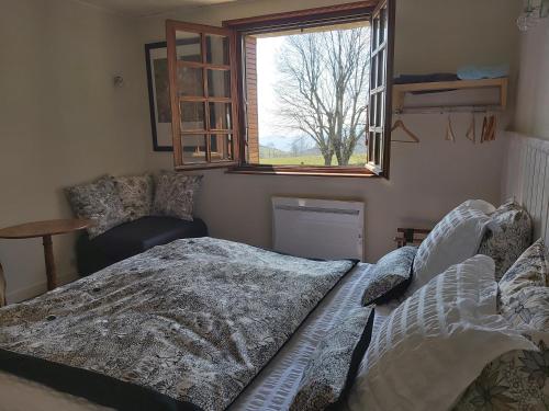 a bedroom with a bed and a window at Ferme Auberge Linossier in Burdignes