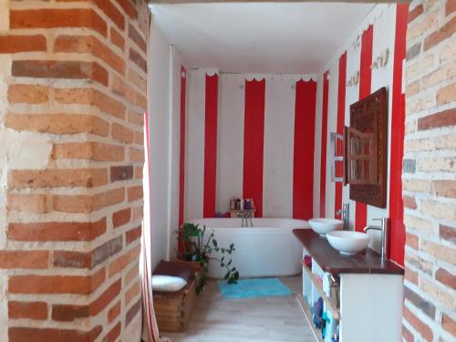 baño con rayas rojas y blancas en las paredes en Ancien Presbytère, en La Chapelle-dʼAngillon