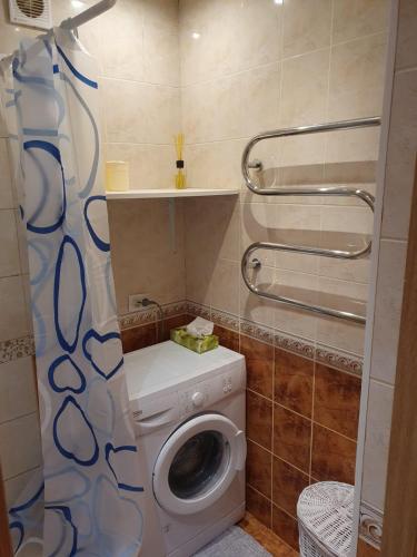 a bathroom with a washing machine and a toilet at Butas Nidos centre in Nida