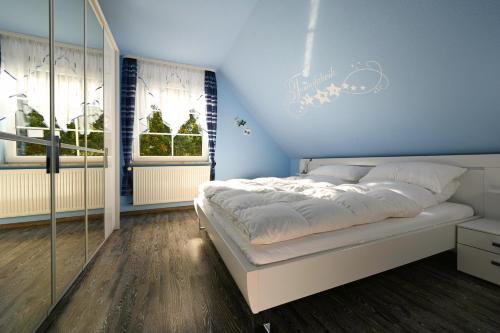 a bedroom with a bed with a blue wall at Haus Johanna in Malchow