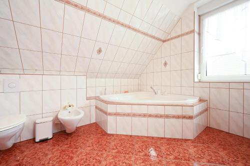 een badkamer met een bad, een wastafel en een toilet bij Haus Johanna in Malchow