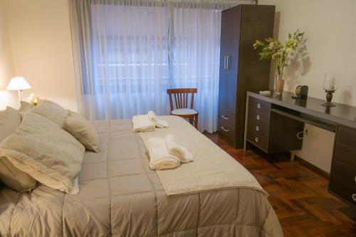 a bedroom with a large bed with towels on it at Departamento del Boulevard in Cordoba