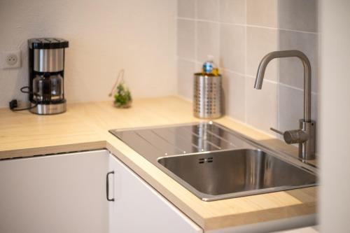 une cuisine avec un évier en acier inoxydable et un comptoir dans l'établissement Le cocon du Vieux-Port, à Marseille