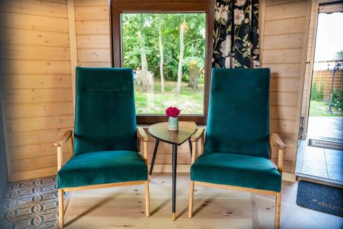 two chairs and a table in a room with a window at Przystanek Czasu - domek kopułowy in Sułów