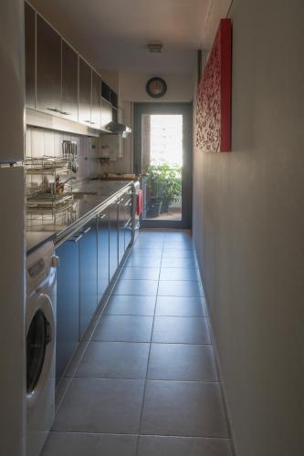 a kitchen with a washer and dryer on a tile floor at Departamento del Boulevard in Córdoba