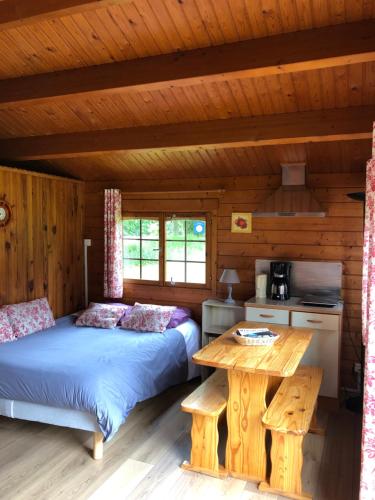 - une chambre avec 2 lits et une table dans une cabine dans l'établissement CHALET GOYAVE, à Épaignes
