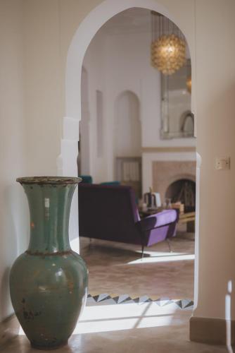 a green vase sitting on the floor in a living room at Les Deux Tours in Marrakech