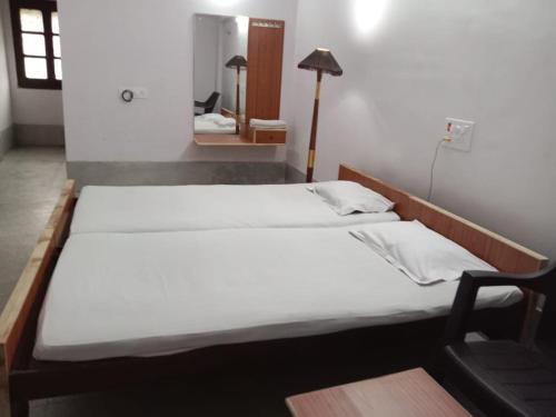 Cama grande en habitación con escritorio y silla en Hotel New Eastern, en Bokāro