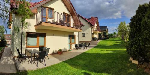a house with a patio with chairs and a table at Promyki - Domki Apartamentowe in Chłopy