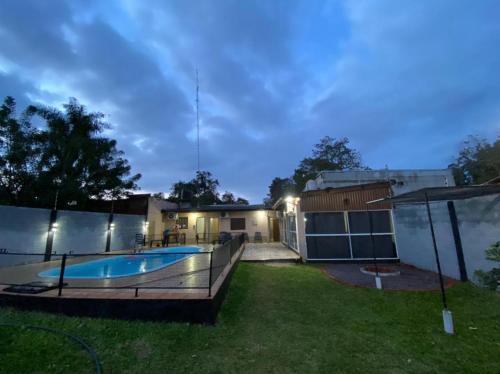 un patio trasero con piscina por la noche en Casa de Fin de semana en Iguazú en Puerto Iguazú