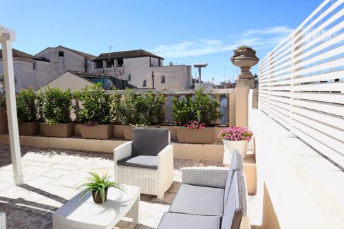 een balkon met stoelen, tafels en potplanten bij Dante 2 B&B in Turi