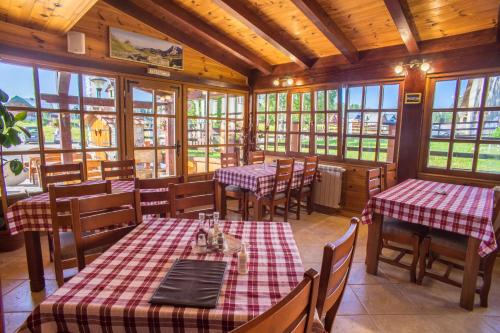 a restaurant with tables and chairs and windows at Hotel Pavlović in Žabljak