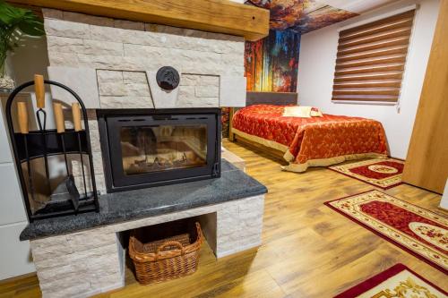 a living room with a fireplace and a bed at Vila Jasen - Bjelašnica in Sarajevo