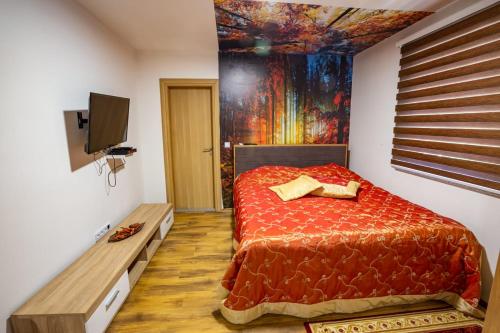 a bedroom with a red bed with a painting on the wall at Vila Jasen - Bjelašnica in Sarajevo
