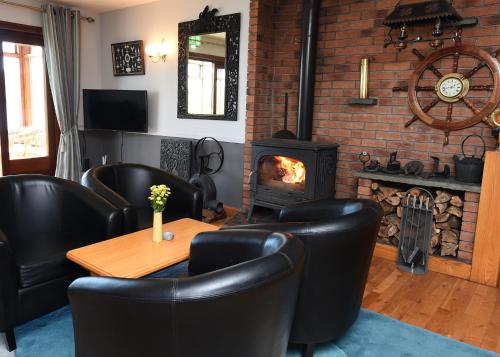 a room with a table and chairs and a fireplace at Whispering Pines in Crosshaven