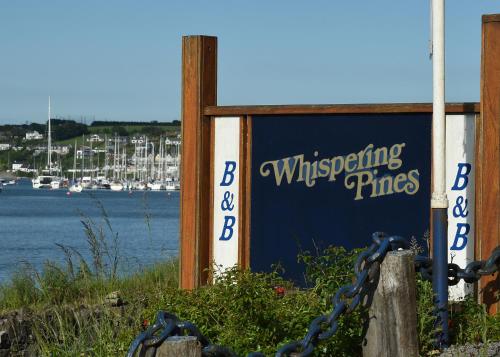 a sign for a wharf with boats in the water at Whispering Pines in Crosshaven