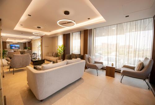 un vestíbulo con sofás y sillas y una gran ventana en Golden Rose Hotel, en Jazan