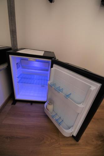 a open refrigerator sitting on a wooden floor at Number 8 in Canterbury