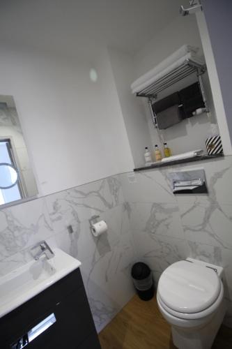 a bathroom with a white toilet and a sink at Number 8 in Canterbury
