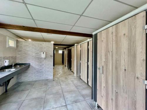 a hallway of a bathroom with sinks and toilets at Le Domaine du Bois Coquet in La Douze