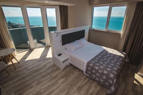 a bedroom with a bed with a view of the ocean at My Sunshine Apartments in Batumi in Batumi