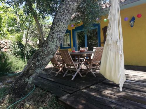 a porch with a table and chairs and a tree at Casa S. Nicolau in Cabeceiras de Basto