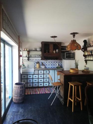 a kitchen with a counter and a table and chairs at Casa S. Nicolau in Cabeceiras de Basto