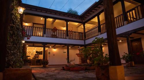 a large building with a balcony with lights at Hotel Campestre El Portón de Los Jeroglíficos in Ramiriquí