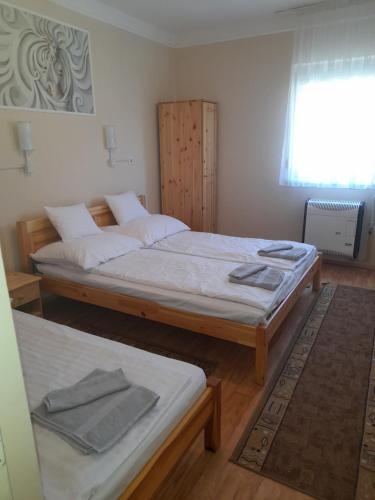 1 dormitorio con 2 camas y ventana en Thermál Apartman Tiszafüred, en Tiszafüred