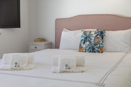 ein Bett mit Handtüchern und Kissen darauf in der Unterkunft Casa da Praca - City Center - Faro in Faro