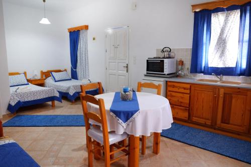 a kitchen with a table with a blue table cloth on it at Petroula Apartments II in Emborios