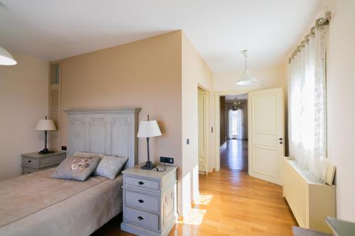 a bedroom with a bed with two lamps and a hallway at Aphrodite Villa in Loutraki