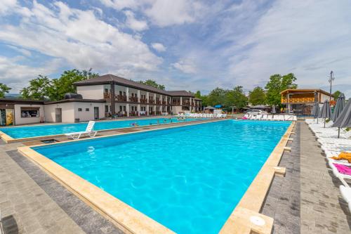 a swimming pool with chairs and a building at PRAHA in Solotvyno
