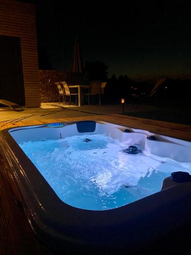 a hot tub in a backyard at night at La Grange du Logis in Waimes