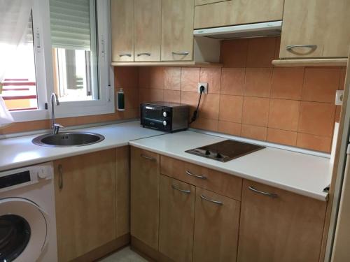 a small kitchen with a sink and a microwave at Apartamento Beach in Los Caños de Meca