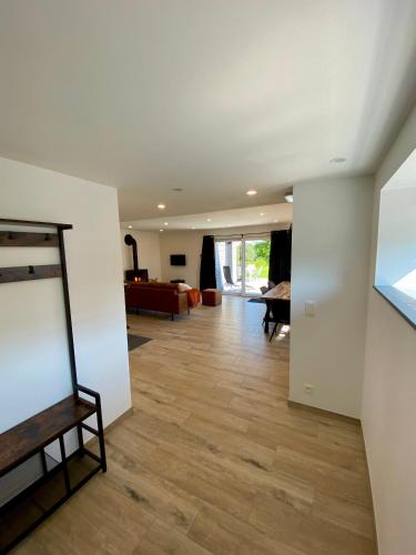 a living room with white walls and a wooden floor at La Grange du Logis in Waimes