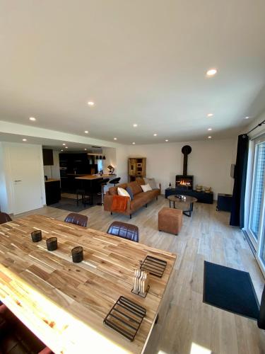 a large living room with a large wooden table at La Grange du Logis in Waimes