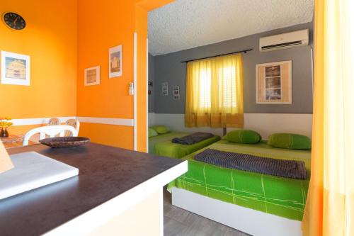 a bedroom with two beds with green cushions at Holiday House Zaton in Nin