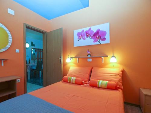 a bedroom with orange walls and a bed with orange pillows at House Vodnjan 2106 in Vodnjan
