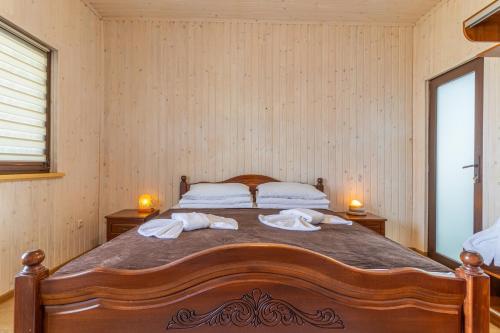 a bedroom with a large wooden bed with towels on it at PRAHA in Solotvyno