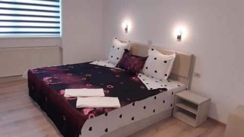 sypialnia z łóżkiem z czarno-białą pościelą i poduszkami w obiekcie Calypso Rooms w Fogaraszu