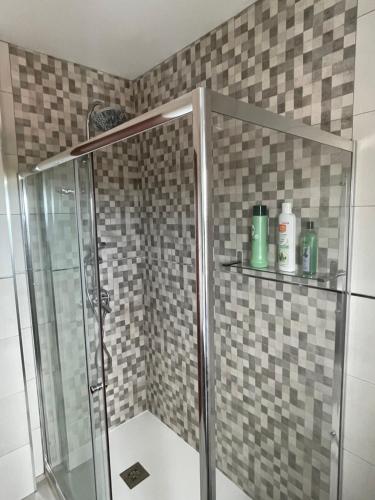 a shower with a glass door in a bathroom at Apartamento Playa de Carnota in Carnota