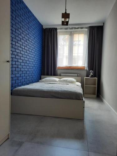 - une chambre avec un lit et un mur bleu dans l'établissement Kryształ A10, Garaż, à Karpacz