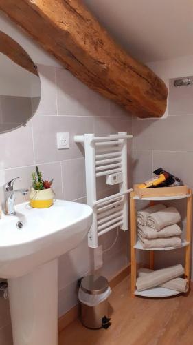 une salle de bain avec un lavabo et une étagère avec des serviettes dans l'établissement Hôtes de Saint-Emilion II, à Saint-Émilion